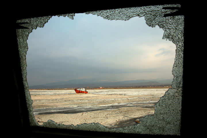 An abandoned boat is seen through the shattered window of an abandoned ship, both stuck in solidified salt at Lake Oroumieh, northwestern Iran. 