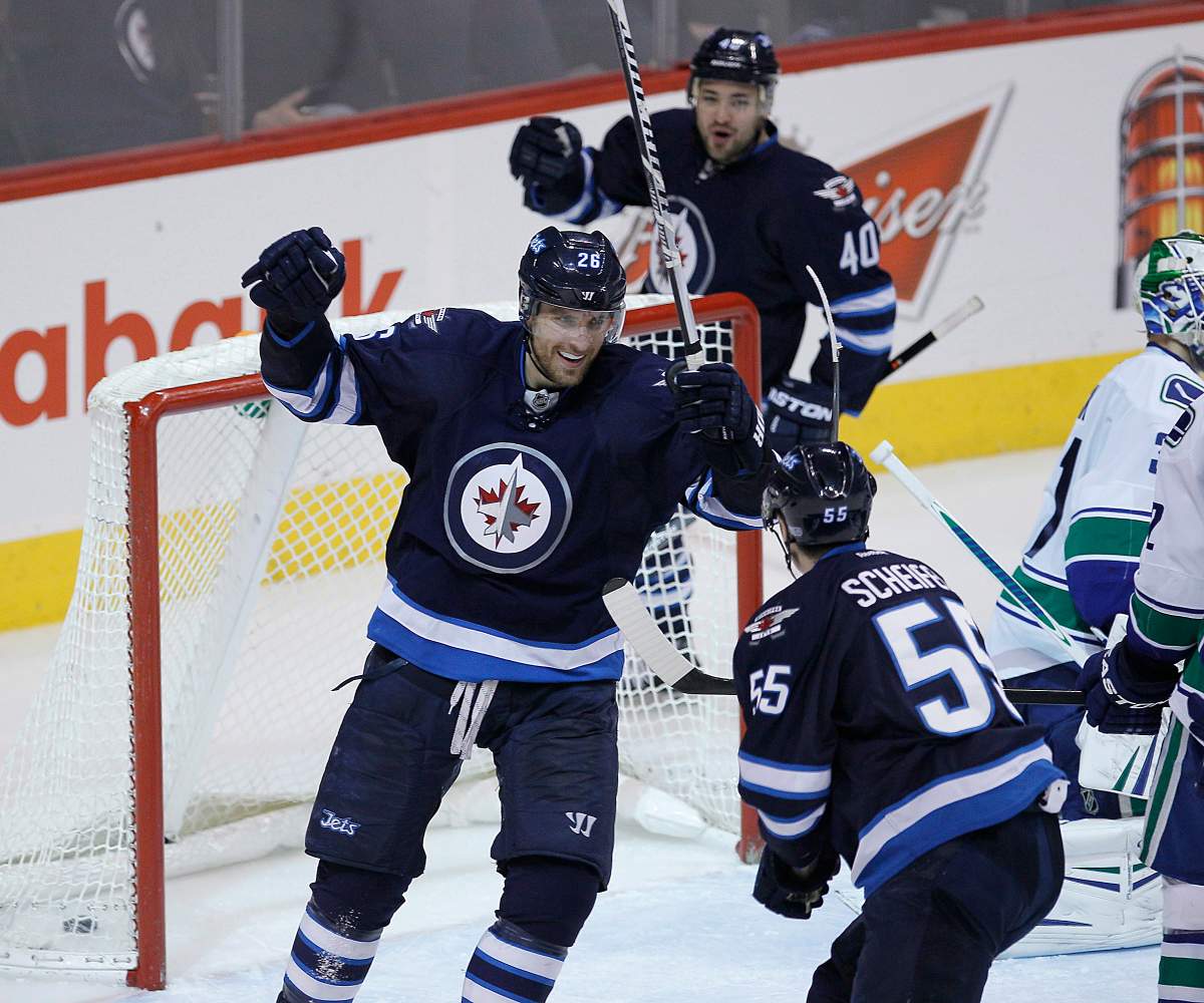 Winnipeg Jets' Blake Wheeler (26), Devin Setoguchi (40) and Mark Scheifele (55) celebrate Setoguchi's game winning goal against the Vancouver Canucks during third period NHL action in Winnipeg on Friday, January 31, 2014. 