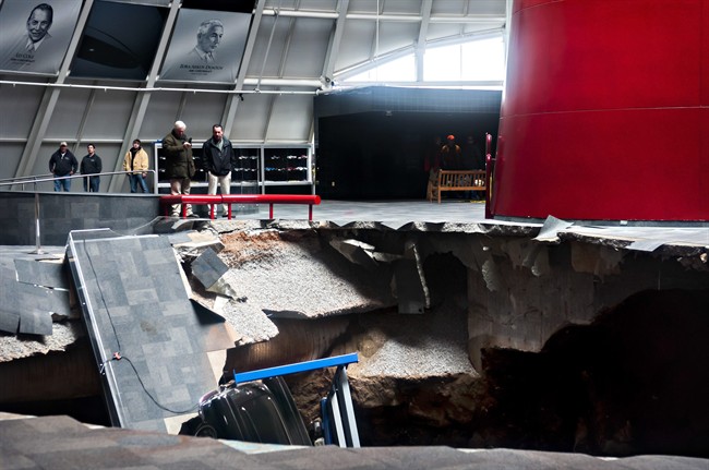 Officials view a sinkhole that opened up in the Skydome showroom, Wednesday, Feb. 12, 2014, at the National Corvette Museum in Bowling Green, Ky. 