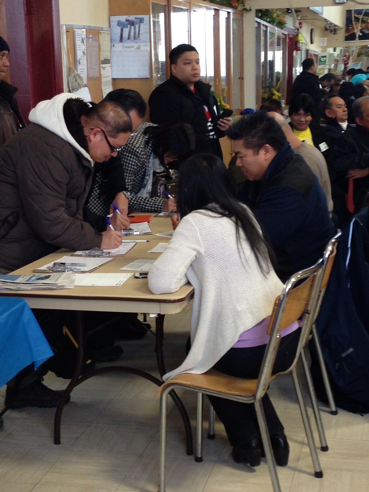Members of Winnipeg's Filipino community register for their first town hall meeting.