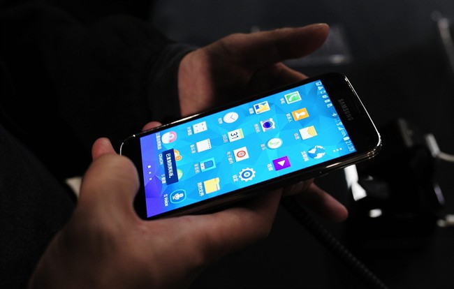 The new Samsung Galaxy S5 is examined by a visitor to the Mobile World Congress.