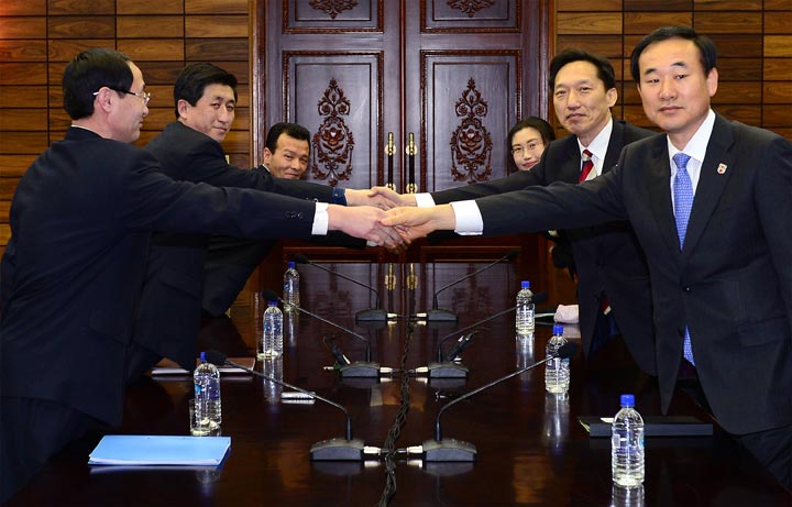   In this handout provided by South Korean Unification Ministry, Lee Duk-Haeng (R, Center), the head of South Korea's working-level delegation to family reunion talks shakes hands with his North Korean counterpart Park Yong-Il (L, Center) during their meeting on February 5, 2014 in Panmunjom, North Korea. 