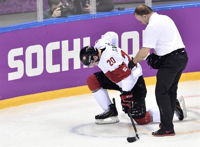 Canada forward John Tavares is helped off the ice after sustaining an injury during second period quarter-final hockey action against Latvia at the 2014 Sochi Winter Olympics in Sochi, Russia on Wednesday, February 19, 2014. 