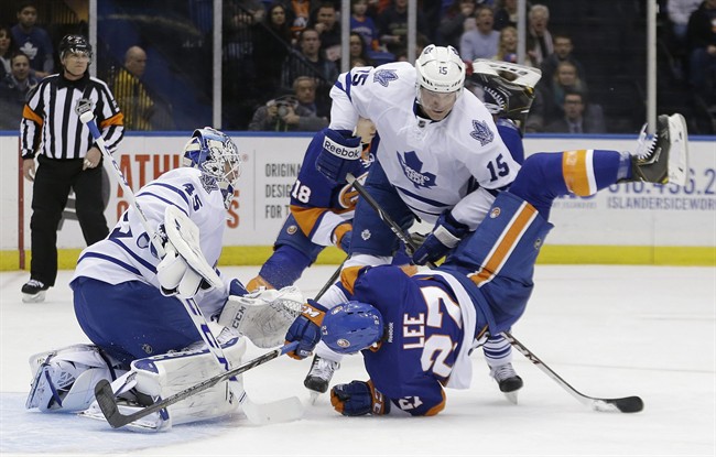 Toronto Maple Leafs' Paul Ranger (15) checks New York Islanders' Anders Lee (27) in front of Jonathan Bernier (45) during the second period of an NHL hockey game Thursday, Feb. 27, 2014, in Uniondale, N.Y.