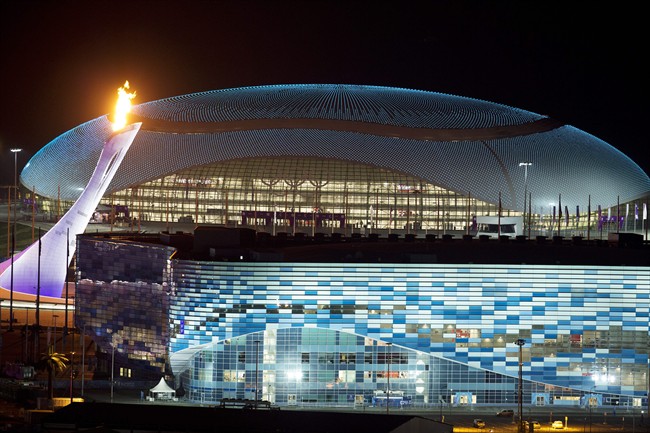  In this Thursday, Feb. 6, 2014 file photo, the Olympic cauldron, left, is lit during a test between the Bolshoy Ice Dome, top, and the Iceberg Skating Palace, foreground, in Sochi, Russia, prior to the start of the 2014 Winter Olympics. 