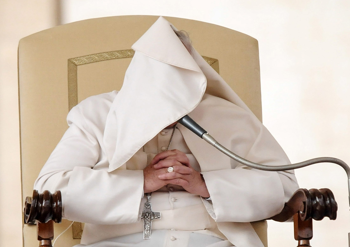 Pope Francis struggles to control his pellegrina in the wind in Vatican City on Feb 19. 2014.