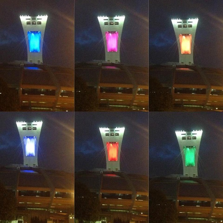 The colours of the rainbow flag glow from the niches of the Olympic tower in Montreal.