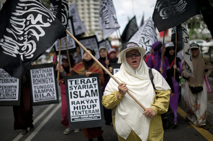 Malaysian Muslim activists carry flags and banners during a peaceful protest against the persecution of Rohingya Muslims in Myanmar, outside the Myanmar embassy in Kuala Lumpur on February 14, 2014. 
