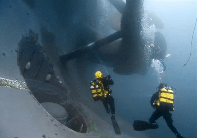  In this undated file photo released by the Italian Fire Brigade, Vigili del Fuoco, Tuesday, Jan. 31, 2012, firemen scuba divers check one of the propellers of the luxury cruise ship Costa Concordia that run ashore off the Tuscany island of Isola del Giglio, Italy. A diver has died Saturday, Feb. 1, 2014, while working on the shipwrecked Costa Concordia in Italy. 