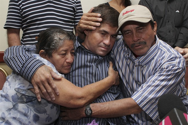 Jose Salvador Alvarenga, a fisherman who says he drifted at sea for more than a year surviving on raw fish, turtles and bird blood, is embraced by his parents, Ricardo Orellana, right, and Maria Julia Alvarenga during a news conference in San Salvador, El Salvador, Tuesday, Feb. 18, 2014. (AP Photo/Salvador Melendez).