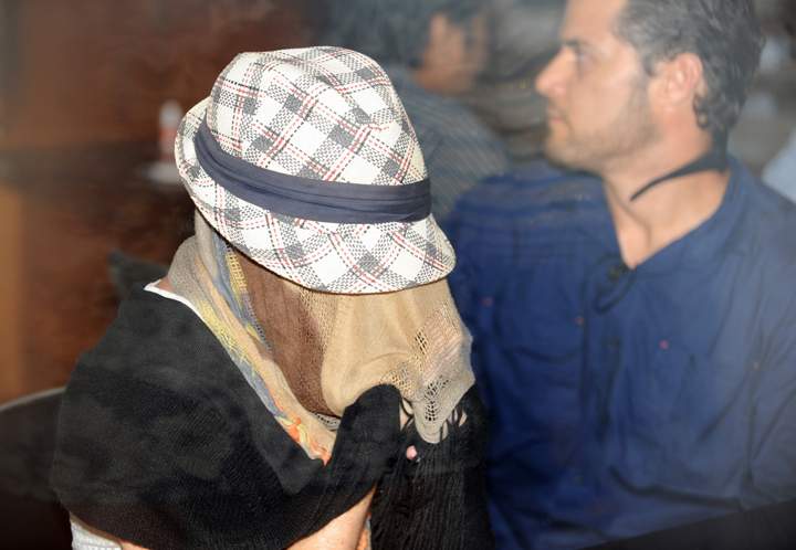 Schapelle Corby sits with her face covered at a correction bureau in Denpasar on Indonesia's resort island of Bali on February 10, 2014.  