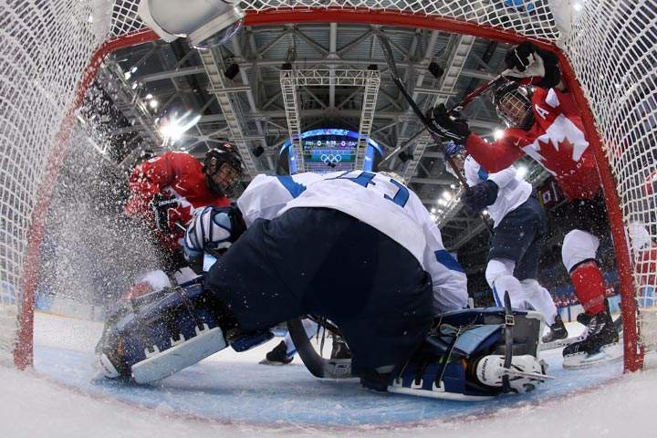 Finland’s goalkeeper Noora Raty vies with Canada’s players during the Women’s Ice Hockey Group A match between Finland and Canada during the Sochi Winter Olympics at the Shayba Arena on February 10, 2014. (Martin Rose/AFP/Getty Images)