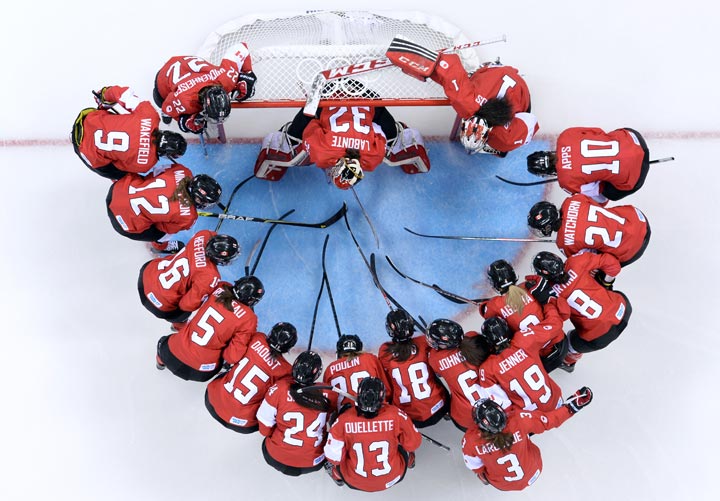 Canada’s player gather before the start of the Women’s Ice Hockey Group A match between Canada and USA at the Sochi Winter Olympics on February 12, 2014 at the Shayba Arena. (Jonathan Nackstrand/AFP/Getty Images)