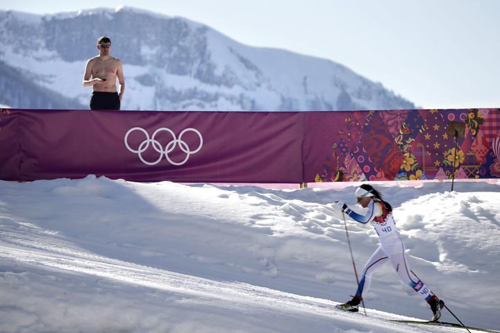 A shirtless spectator watches Sweden’s Charlotte Kalla compete during the women’s 10K classical style cross-country race at the 2014 Winter Olympics, Thursday, Feb. 13, 2014, in Krasnaya Polyana, Russia. (AP Photo/Jae C. Hong)