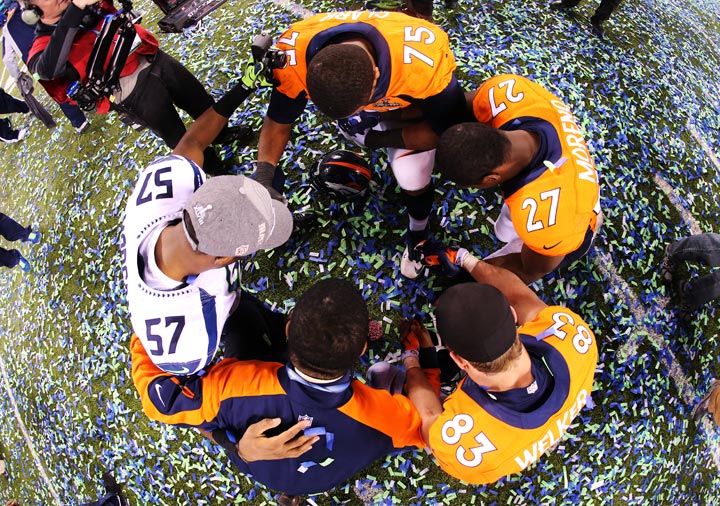 Outside linebacker Mike Morgan of the Seattle Seahawks  gathers with Broncos players after Super Bowl XLVIII at MetLife Stadium on February 2, 2014 in East Rutherford, New Jersey. The Seahawks beat the Broncos 43-8.  (Jamie Squire/Getty Images)
.