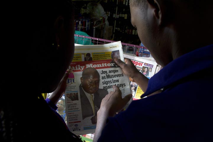 People read Uganda's local dailies in Kampala on February 25, 2014.  On Monday, President Yoweri Museveni signed a bill into law which holds that repeat homosexuals should be jailed for life, outlaws the promotion of homosexuality and requires people to denounce gays. 
