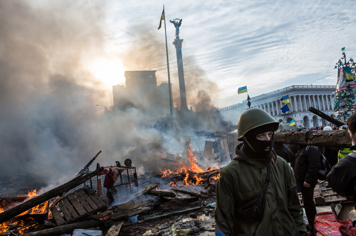Anti-government protesters walk amid debris and flames near the perimeter of Independence Square, known as Maidan, on February 19, 2014 in Kyiv, Ukraine.