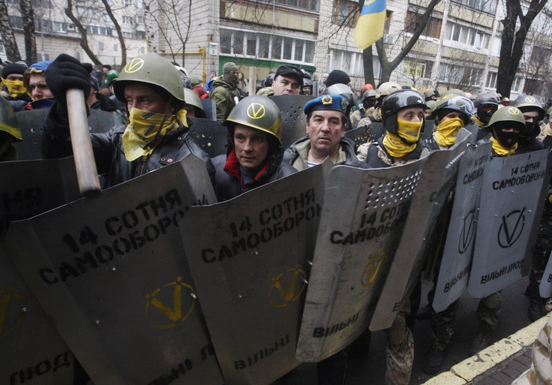 Anti-government protestors of the '14 Hundred Self-Defense' group take part in a protest rally in front of the Prosecutor General building in Kiev on February 14, 2014. Protesters armed with shields and clubs demanded the government stop prosecuting cases against anti-government activists involved in clashes with police. AFP PHOTO / YURY KIRNICHNY .