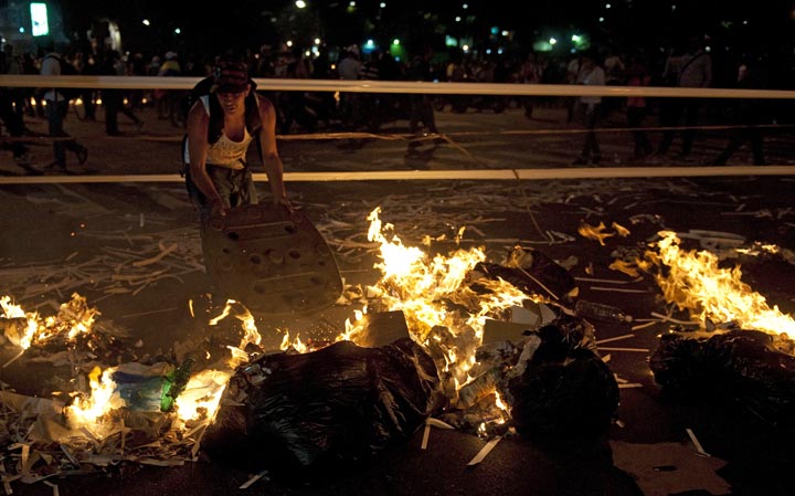 A Venezuelan anti-government student lights a fire during clashes with riot policemen following a protest, in Caracas on February 20, 2014. Raul Arboleda/AFP/Getty Images.