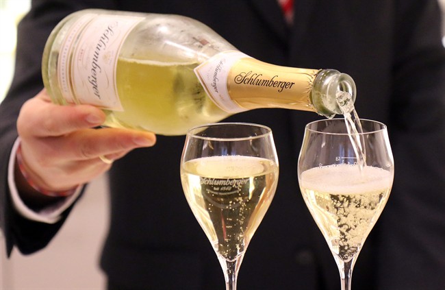 In this picture taken Friday, Jan. 31, 2014, Benedikt Zacherl spokesperson of sparkling wine manufacturer Schlumberger fills two glasses with sparkling wine in Vienna, Austria.