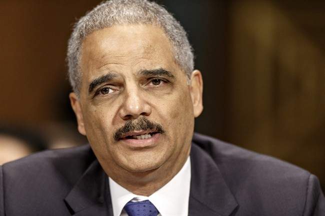 In this Jan. 29, 2014 file photo, Attorney General Eric Holder testifies on Capitol Hill in Washington. In an assertion of same-sex marriage rights, Holder is applying a landmark Supreme Court ruling to the Justice Department, announcing Saturday that same-sex spouses cannot be compelled to testify against each other, should be eligible to file for bankruptcy jointly and are entitled to the same rights and privileges as federal prison inmates in opposite-sex marriages. (AP Photo/J. Scott Applewhite, File).