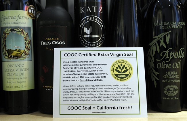 This photo taken Feb. 12, 2014 shows a card bearing a certification sticker for California olive oil displayed at the All Things Olive shop in Washington. It's a pressing matter for the tiny U.S olive oil industry. Shoppers are more often pouring European oil _ it's cheaper and viewed as more authentic than the American competition. And that's pitting U.S. producers against importers of the European oil. Some liken the battle to the California wine industry's struggles to gain acceptance decades ago. The tiny California olive industry says European olive oil filling U.S. shelves often is mislabeled and lower grade. They're pushing the federal government to give more scrutiny to imported varieties. One congressman-farmer even goes as far as suggesting labels on imported oil say "extra rancid" rather than extra virgin. Stricter standards might help American producers grab more market share from the dominant Europeans. 