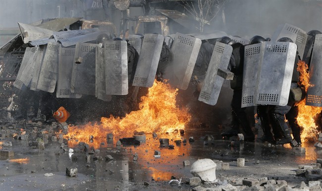 Riot police clash with anti-government protesters outside Ukraine’s parliament in Kyiv, Ukraine, Tuesday, Feb. 18, 2014.