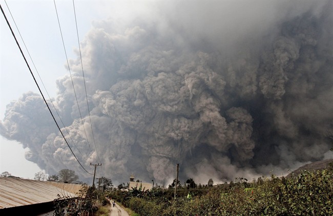 Mount Sinabung releases pyroclastic flows during an eruption as seen from Namantaran, North Sumatra, Indonesia, Saturday, Feb. 1, 2014. 