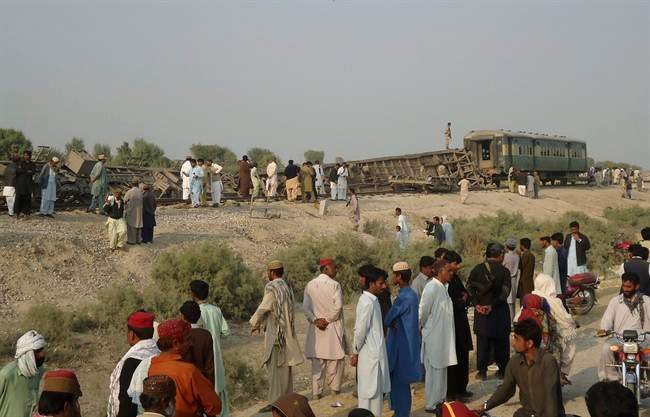 Pakistanis gather at the site of a deadly bomb blast that hit a train, in Kashmor district, Pakistan, Sunday, Feb. 16, 2014. 