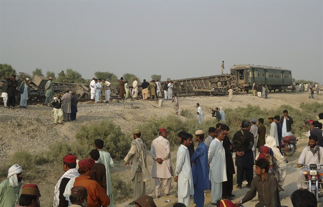 Pakistanis gather at the site of a deadly bomb blast that hit a train, in Kashmor district, Pakistan, Sunday, Feb. 16, 2014. 