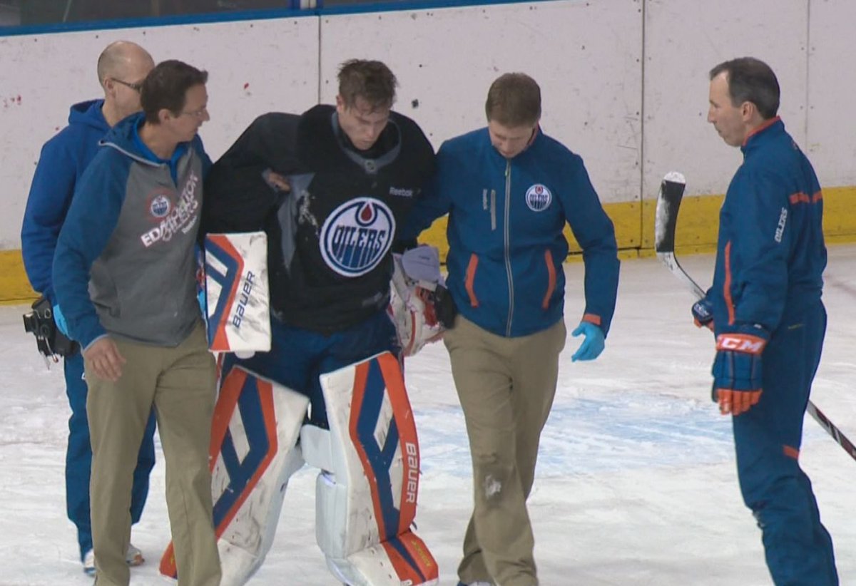 Edmonton Oilers goalie Viktor Fasth was helped off the ice Monday, March 24, 2014 after colliding with teammate Anton Lander during practice in Edmonton.