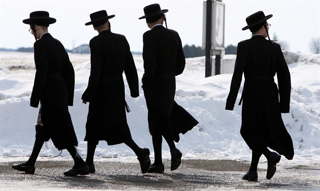 Members of the Lev Tahor ultra-orthodox Jewish sect walk down a street in Chatham, Ont., Wednesday, March 5, 2014. 