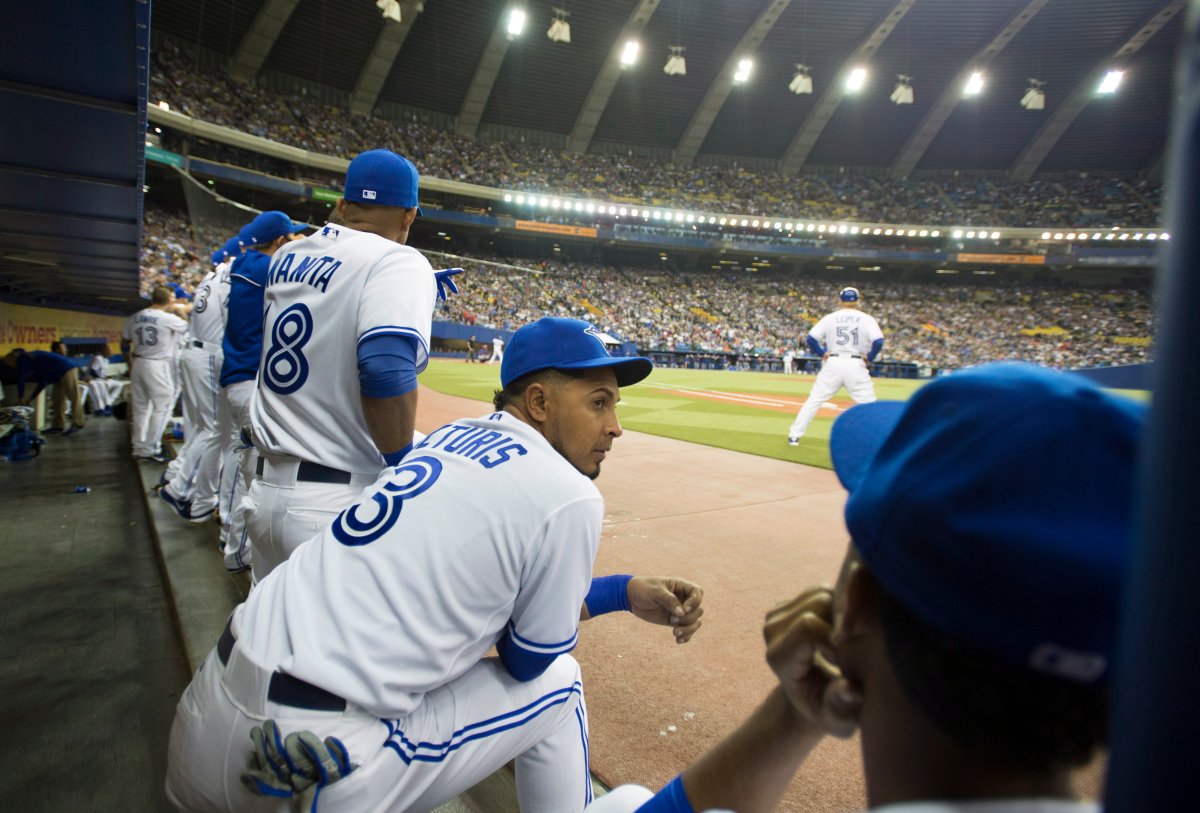 Fans wear Montreal Expos uniforms as they watch the Toronto Blue Jays in a  pre-season baseball game against the New York Mets Friday, March 28, 2014  in Montreal. A study commissioned by