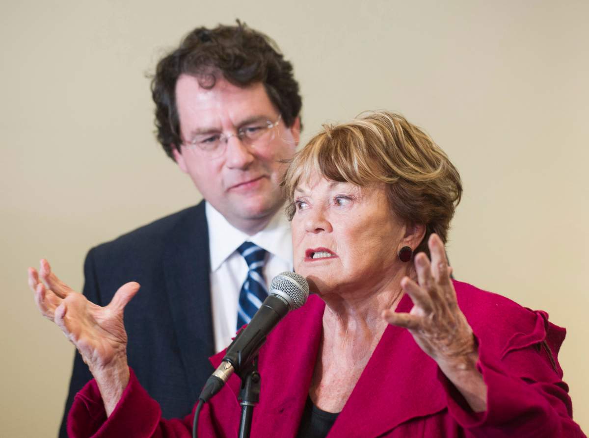 Parti Quebecois Minister Bernard Drainville listens as women's rights activist Janette Bertrand speaks during a Quebec provincial election campaign stop at a restaurant in Laval.
