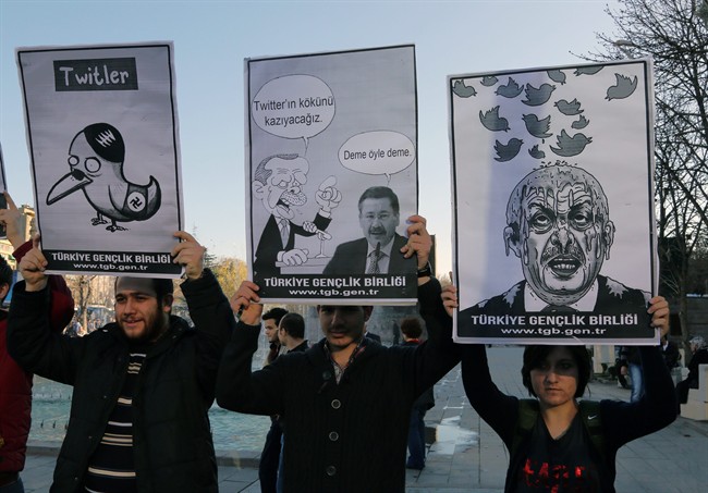 Members of the Turkish Youth Union hold cartoons depicting Turkey's Prime Minister Recep Tayyip Erdogan during a protest against a ban on Twitter, in Ankara, Turkey, Friday, March 21, 2014. (AP Photo/Burhan Ozbilici).
