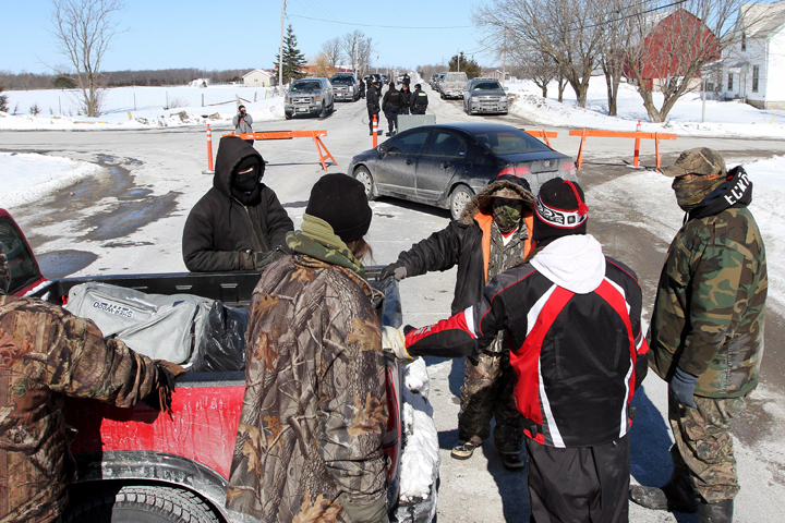 Native protesters block a road near Shannonville, Ont., while O.P.P., officer keep an eye on the traffic on Monday March 3, 2014.