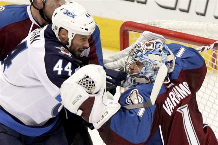 The Winnipeg Jets' Zach Bogosian gets tangled up with Colorado Avalanche goalie Semyon Varlamov on Monday in Denver.