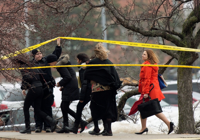 People leave the Brampton courthouse hours after a gunman opened fire in the court house injuring a police officer in Brampton, Ont., on Friday, March 28, 2014.