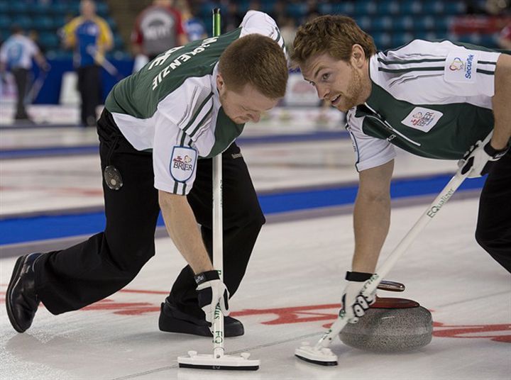 Prince Edward Island's Anson Carmody, right, and Tyler MacKenzie sweep as they play Nova Scotia at the Tim Hortons Brier in Kamloops, B.C., on Sunday.