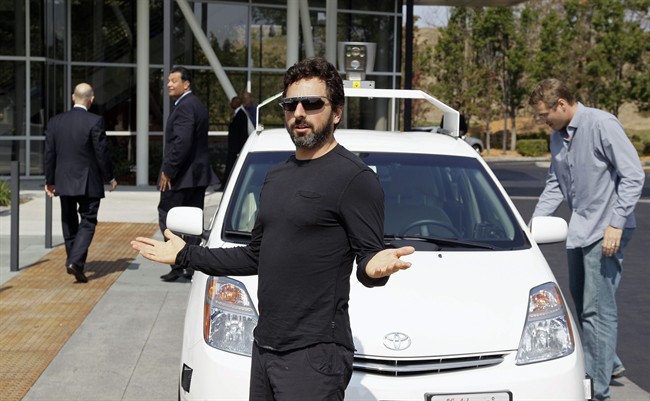 In this Sept. 25, 2012 file photo, Google co-founder Sergey Brin gestures after riding in a driverless car with California Gov. Edmund G Brown Jr., left, and state Senator Alex Padilla, second from left, to a bill signing for driverless cars at Google headquarters in Mountain View, Calif. 