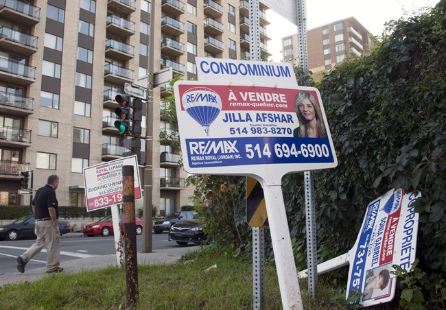 For sale signs stand in front of a condominium in Montreal. The city posted record August home sales as average prices rose 4.1 per cent. Thursday, Sep.7, 2017.