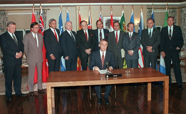 Prime Minister Brian Mulroney sits and reads a statement after he and the provincial premiers reached an agreement in principal on constitutional grievances, after meeting at Meech Lake, April 30, 1987.