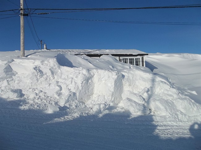 Janice Gould and Rick Cooper's house in Port au Choix, N.L., is almost completely buried under a thick blanket of snow on Wednesday, March 19, 2014.