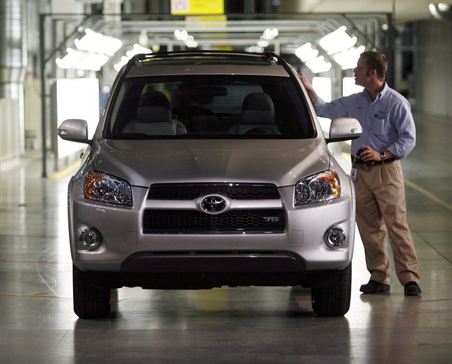 An employee looks over a Rav 4 vehicle at the end of the assembly line, at the opening of the Toyota Motor Manuafacturing Canada, Inc. new automotive plant in Woodstock, Ont., Thursday December 4, 2008. 