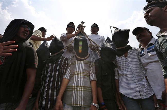 FILE - In this Tuesday, Sept. 10, 2013 file photo, Indian protesters stage a mock hanging scene demanding death sentences for four men after a judge convicted them in the fatal gang rape of a young woman in New Delhi, India. 