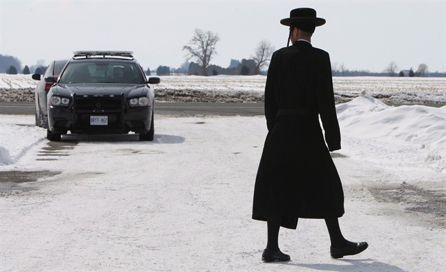 Members of the Lev Tahor ultra-orthodox Jewish sect walk down a street in Chatham, Ont., Wednesday, March 5, 2014.
