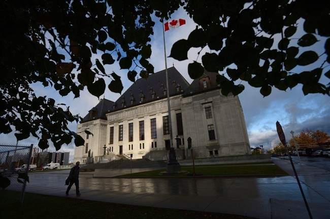 A pedestrian walks past the Supreme Court of Canada in Ottawa, Oct. 18, 2013. 