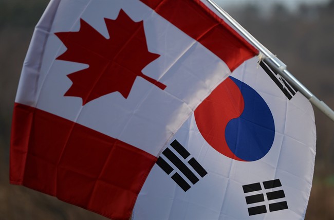 A Canadian flag and a South Korean flag fly in Yongin, South Korea on Tuesday, March 10, 2014.