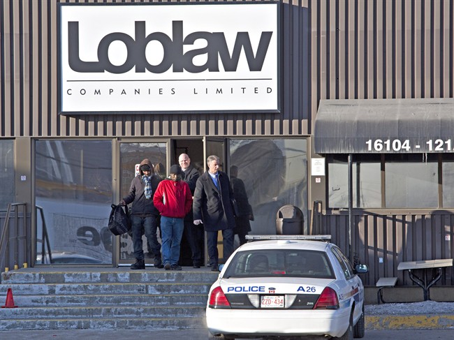 Police detectives walk out with witnesses as they investigate the scene where two people are dead and four people in hospital after a stabbing at a Loblaws warehouse in Edmonton, Alberta on Friday February 28, 2014.