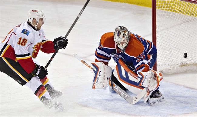 Calgary Flames' Matt Stajan (18) scores a goal against Edmonton Oilers goalie Viktor Fasth (35) during second period NHL hockey action in Edmonton, Alta., on Saturday March 22, 2014.